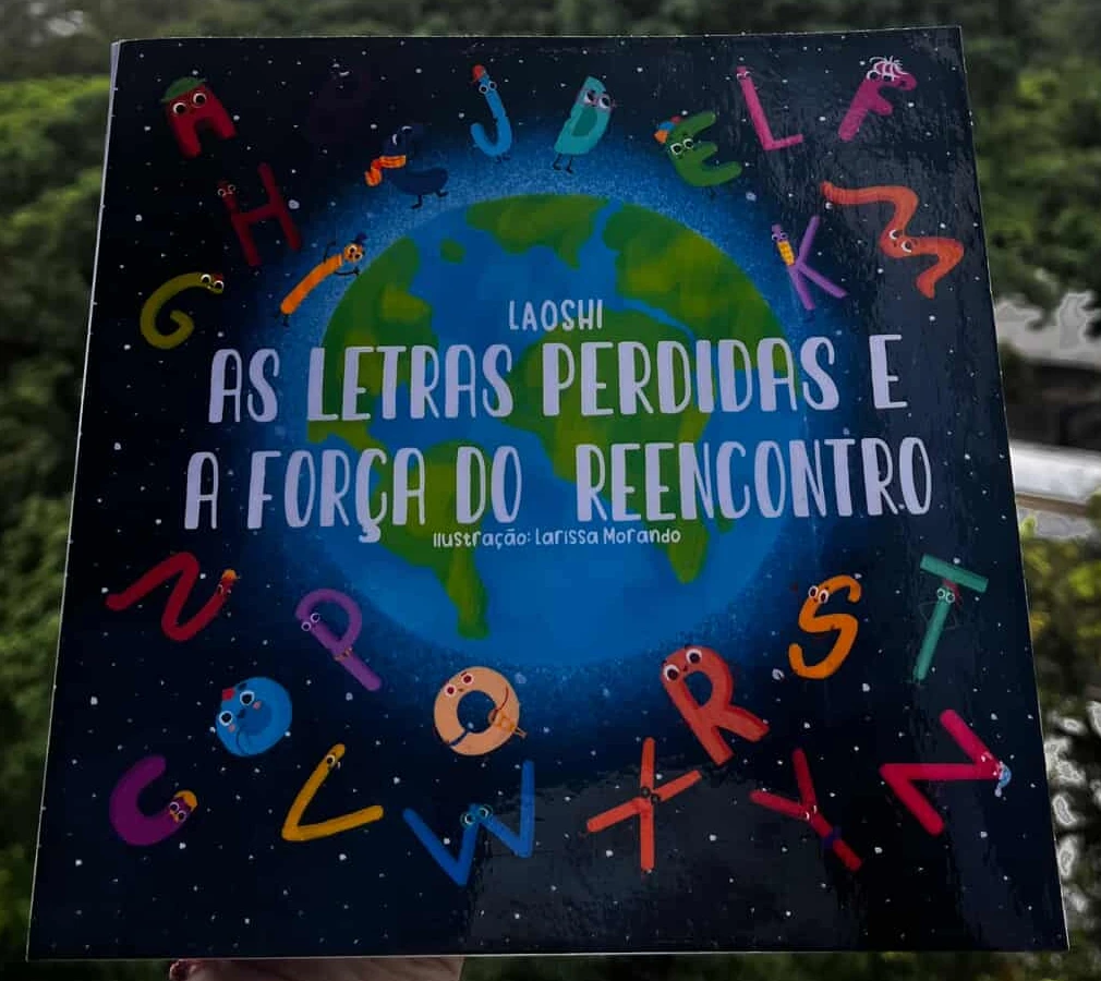 Fotografia do exemplar físico de As Letras Perdidas e a Força do Reencontro, com a capa azul e letras personagens ao redor do planeta Terra.